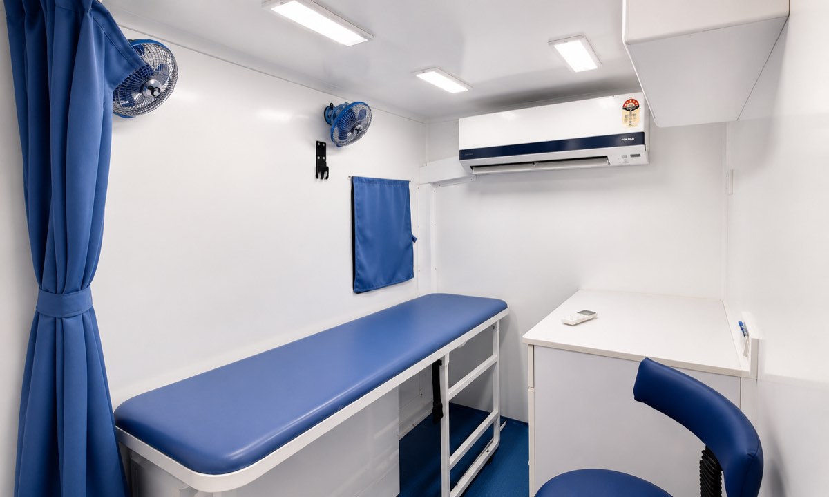 The examination area with a cushioned patient bed, doctor workstation and air conditioning